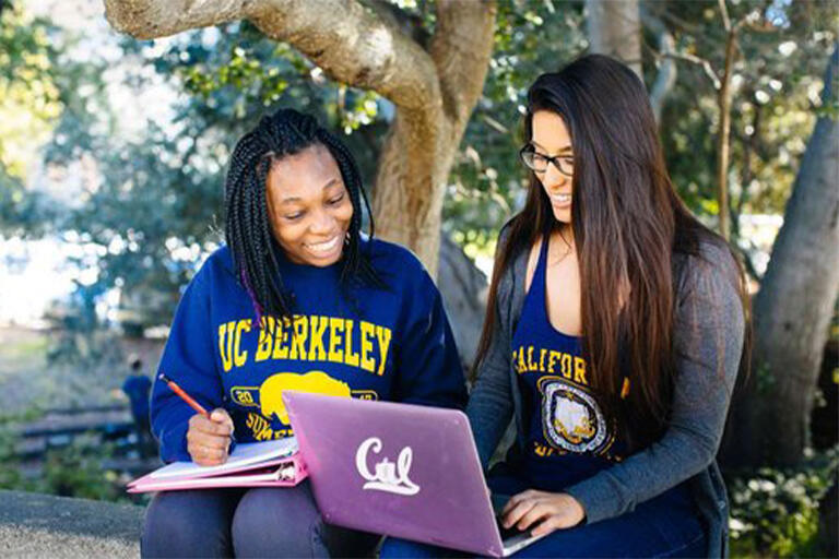 Two UC Berkeley students taking notes from a laptop