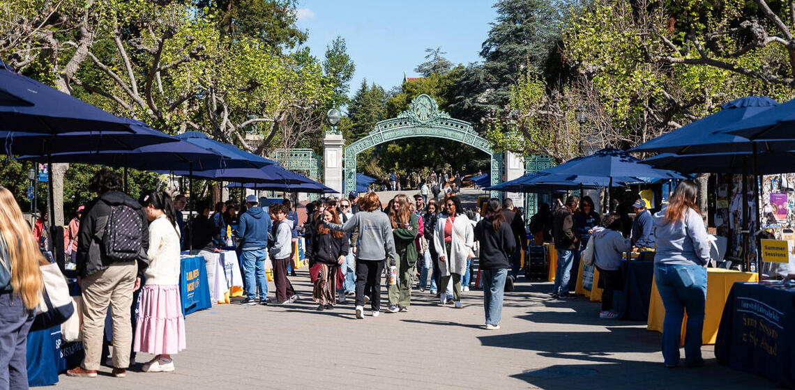 Resource fair taking place on Lower Sproul, viewed from the south side of Sather Gate, looking toward the event and gate.
